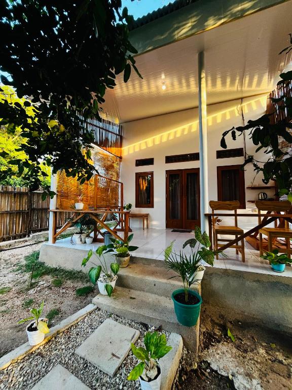 a house with a porch with a bunch of plants at Lomba Oen bungalow in Nembrala