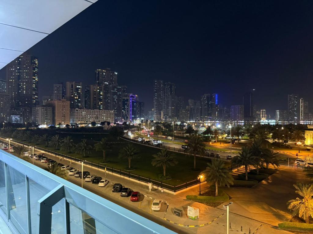 a city at night with cars parked in a parking lot at Unmatched Location - A Large 2BR Sea-facing Flat in Sharjah