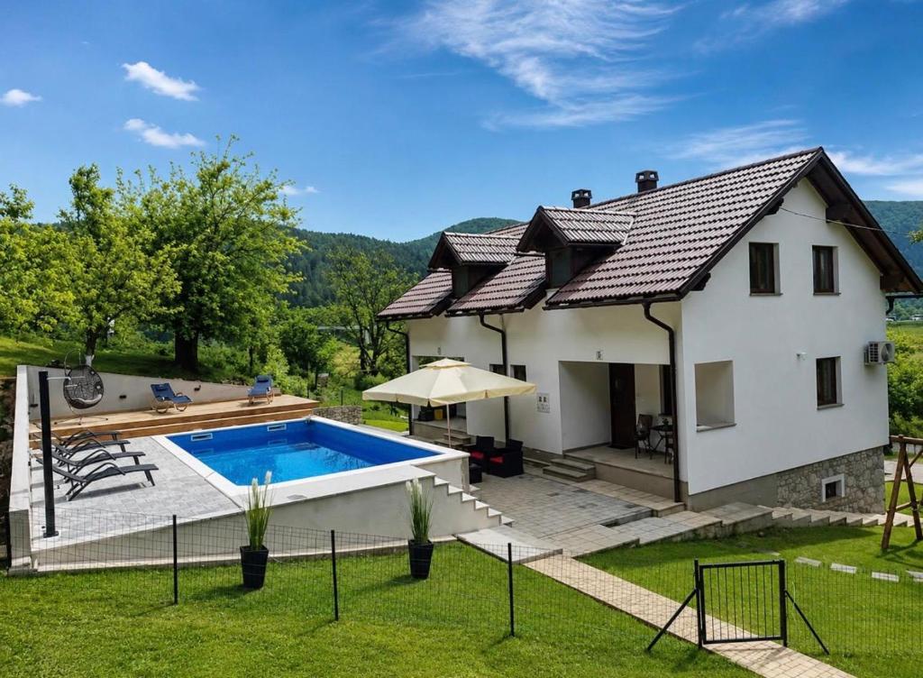 a house with a swimming pool in the yard at Holiday House Marija in Otočac