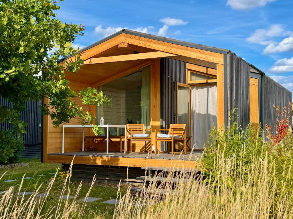 a tiny house with a deck and a table at 204 Hochwertiges Tiny House mit Wiesenblick in Bleckede