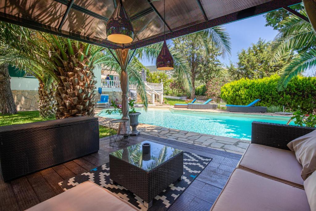 an outdoor patio with a swimming pool and a villa at Villa Euphoria in Theológos