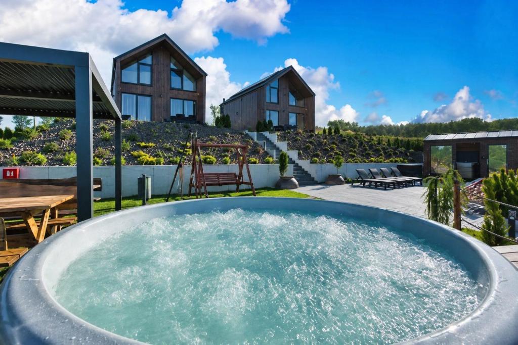 a hot tub on the patio of a house at Zajęcze Domki in Zagórze Śląskie
