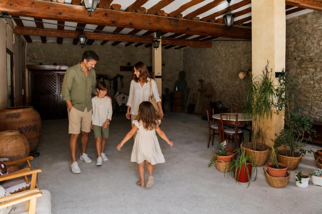 a family walking through a garage with a little girl at Masía El Losar - Casa Rural Exclusiva Castellón in Villafranca del Cid
