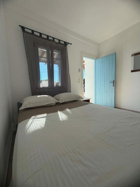 a large bed in a bedroom with a window at Lefkanemos in Tourlos