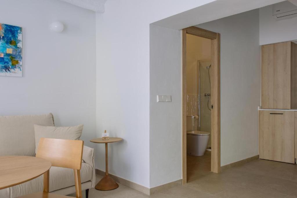 a white room with a table and a bathroom at Artemaris by Seaward Suites in Villajoyosa
