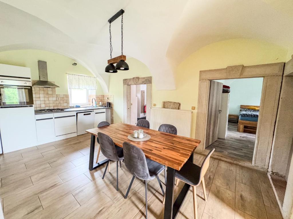 a kitchen and dining room with a wooden table and chairs at Apartmán 56 in Božanov