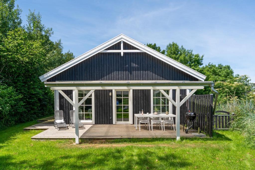 a black and white house with a table on a deck at Ahoi Lee in Blekendorf