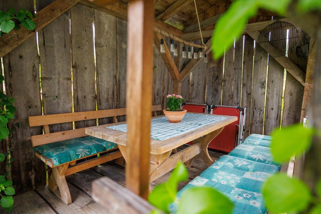 a wooden table and bench with a potted plant on it at Ferienhaus Hallweger inkl. Chiemgaukarte in Ruhpolding