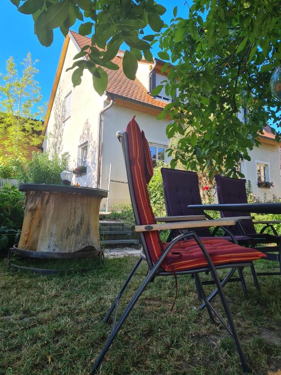 two chairs and a table in front of a house at Ferienhaus Blumenstock in Steinsfeld