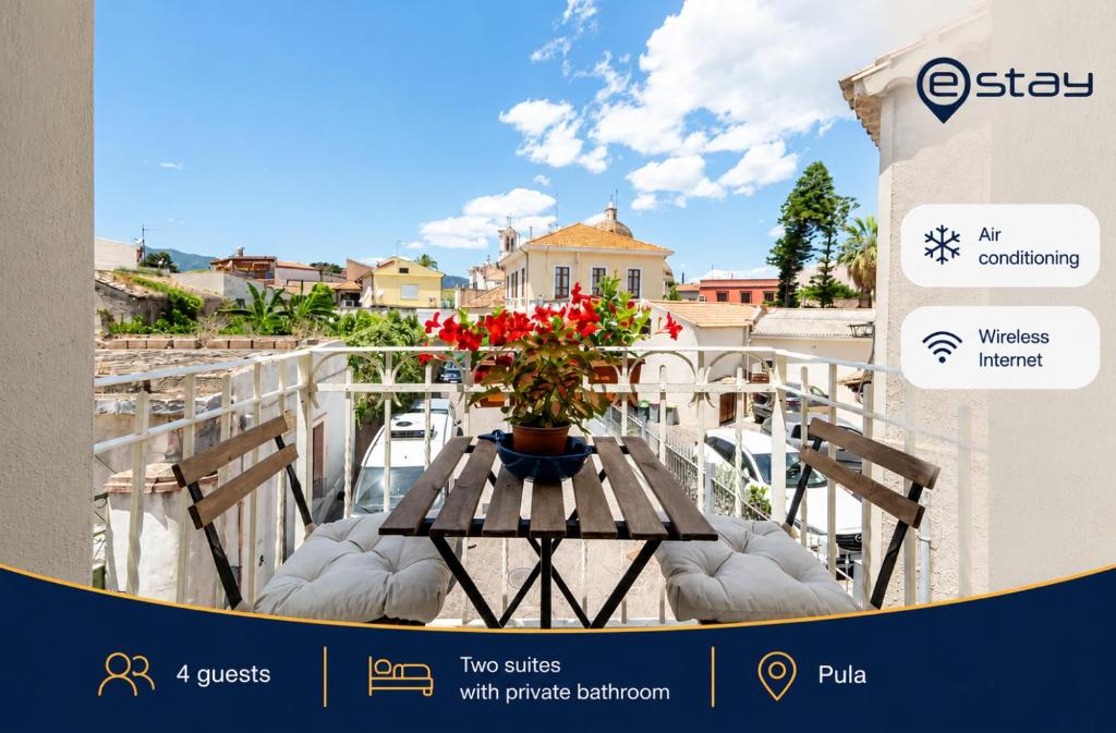 a table with a vase of flowers on a balcony at Estay - Il Ginepro - Luxury Suites in Pula