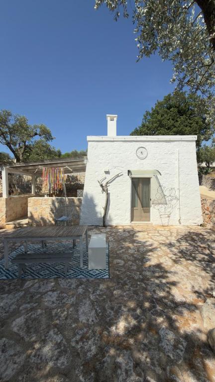 a small white building with a bench in front of it at La Mia Lamia in Cisternino