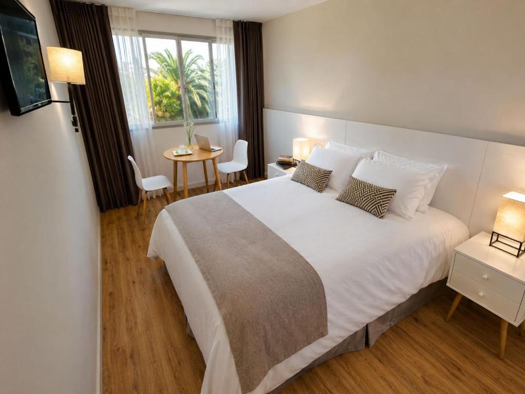 ein Schlafzimmer mit einem großen weißen Bett und einem Tisch in der Unterkunft Hotel Flores in Trinidad