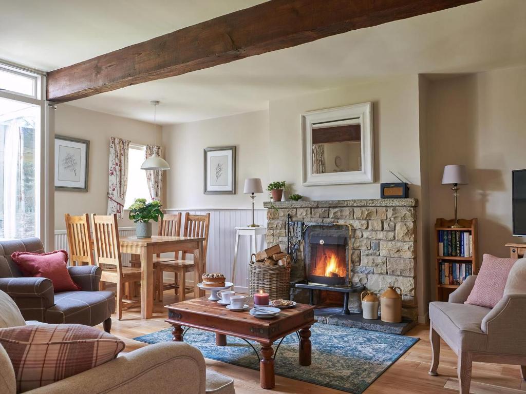 a living room with a fireplace and a table at Farndale in Pickering