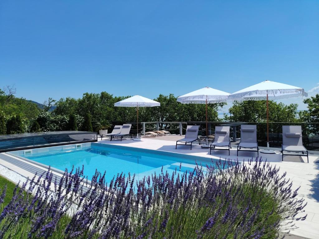 a swimming pool with lounge chairs and umbrellas at Villa17 in Badacsonytomaj