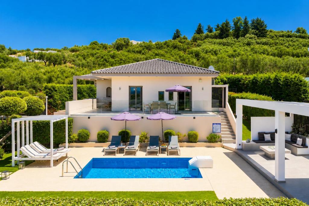 a villa with a swimming pool and a house at Villa Vatia 2 in Tragaki