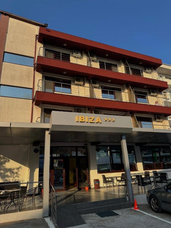 a building with tables and chairs in front of it at Hotel Ibiza in Eforie Nord