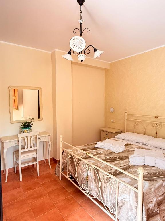 a bedroom with a bed and a table and a clock at Agriturismo Il Vecchio Carrubo in Castellammare di Velia