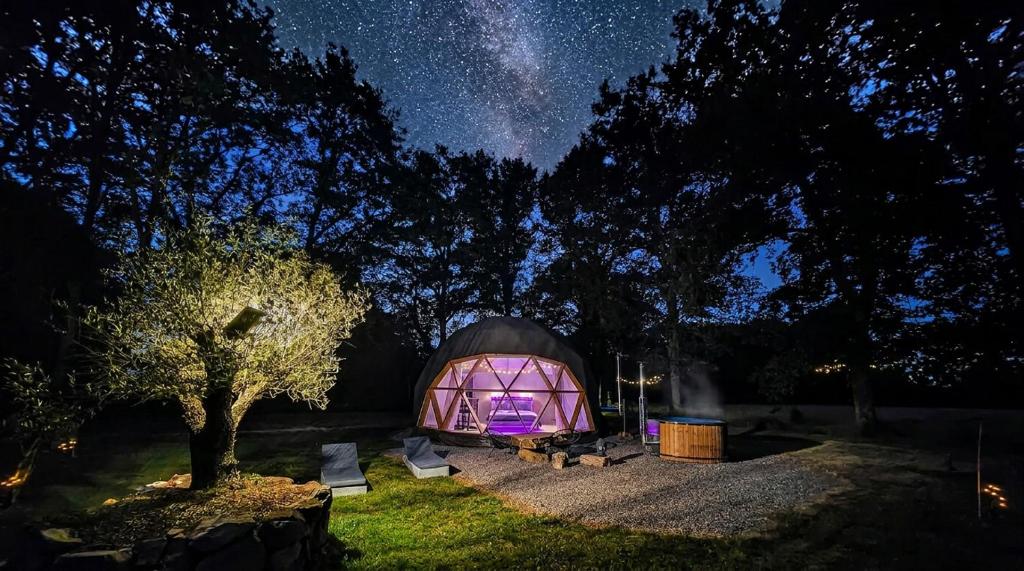a large dome tent with chairs in a field at night at Dôme Bao SPA luxe climatisé in Lesterps