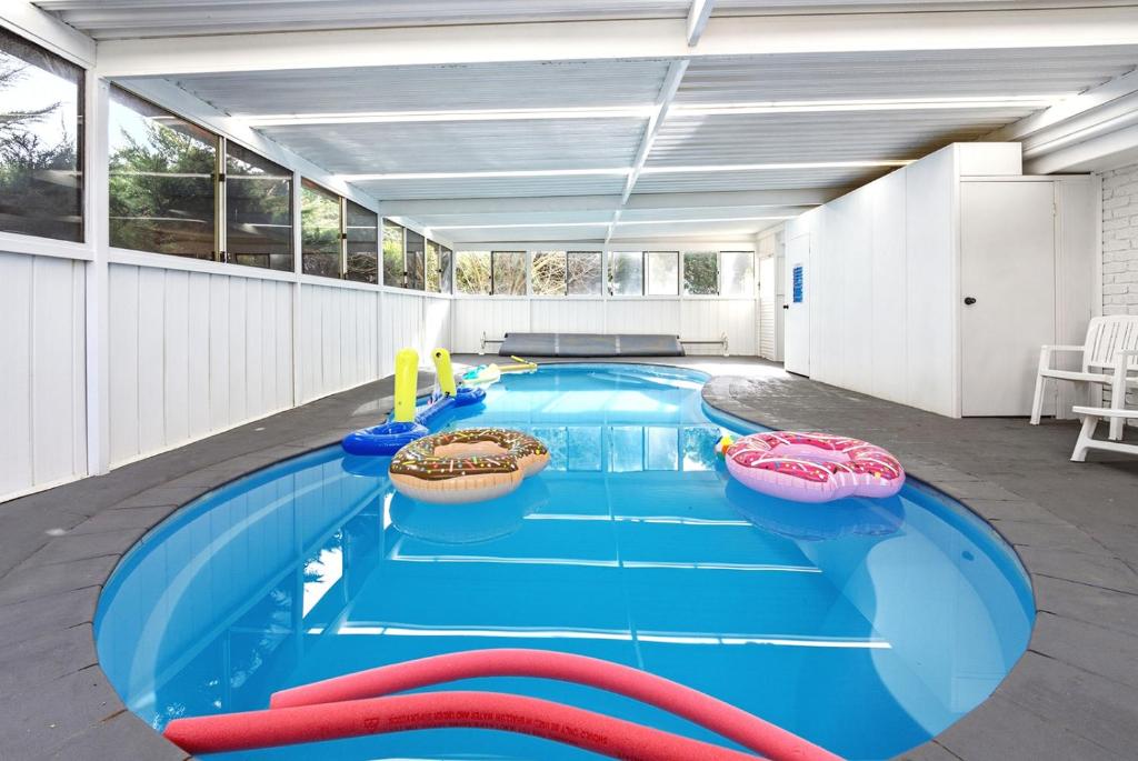 a large swimming pool with red inflatables in a building at Blue Willow Bathurst Country Getaway in Bathurst