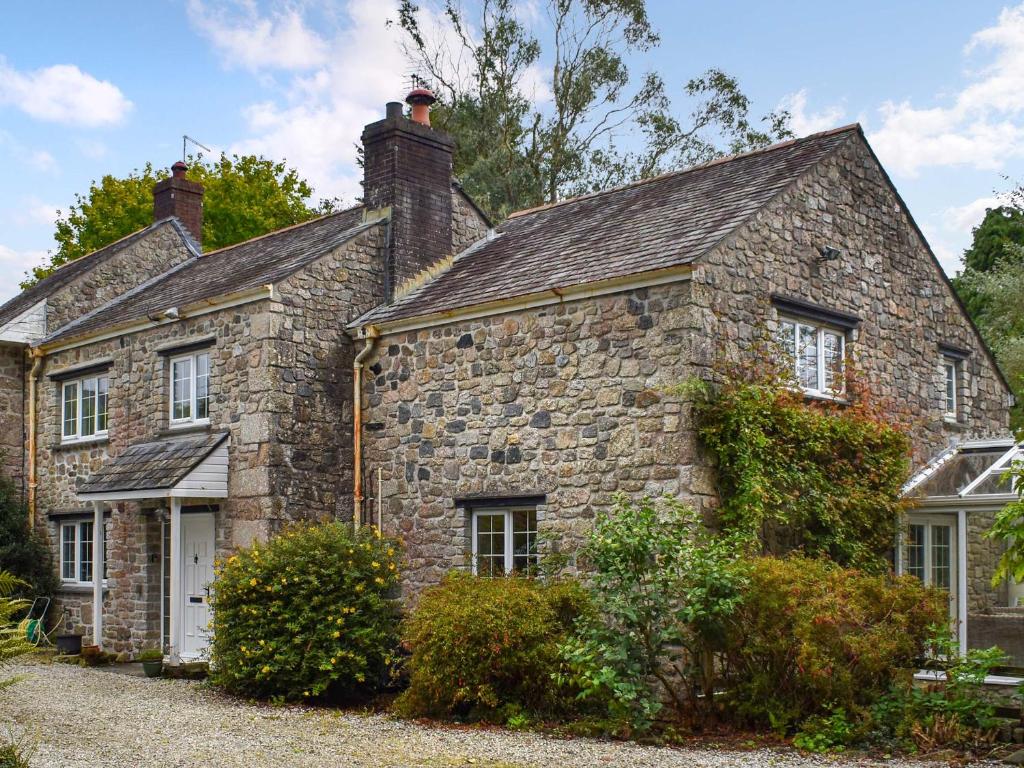 an old stone house with a roof at Prideaux Cottage in Par