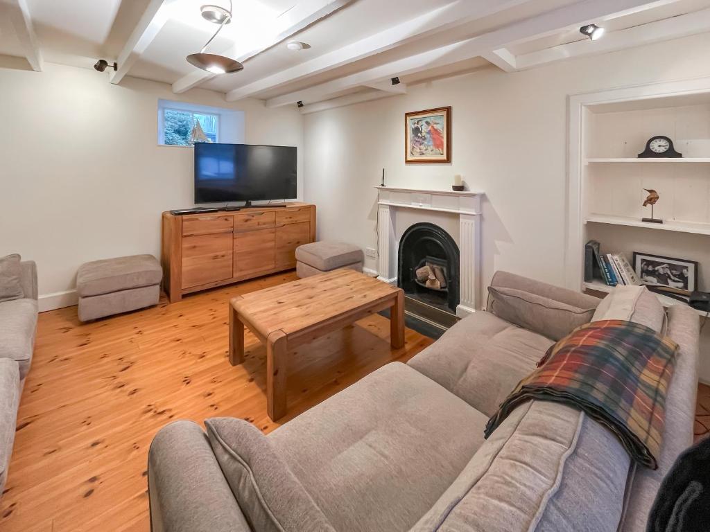 a living room with a couch and a tv and a fireplace at Faodail in Plockton