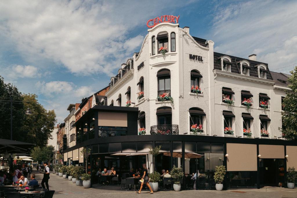 a white building with a sign on top of it at Hotel The Century in Hasselt