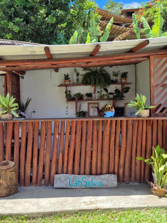 a wooden fence with a bunch of potted plants at LahSelva Pousada e Hostel in Itacaré