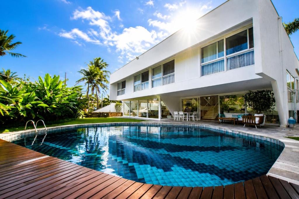 a swimming pool in front of a house at Savay Hotel Boutique - Guarujá in Guarujá
