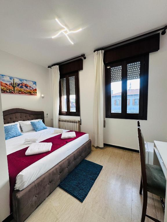 a bedroom with a bed and a desk and windows at Alisa house Venice in Venice