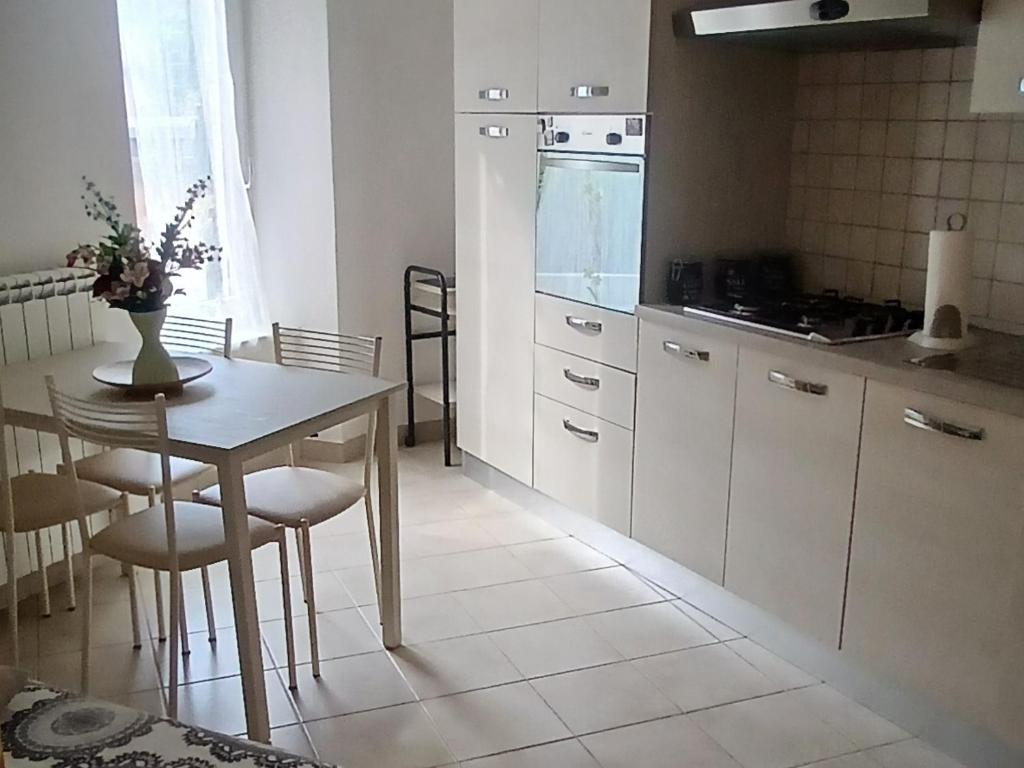 a kitchen with a table and chairs and a kitchen with a stove at Appartamento Casa Margi in Ameglia
