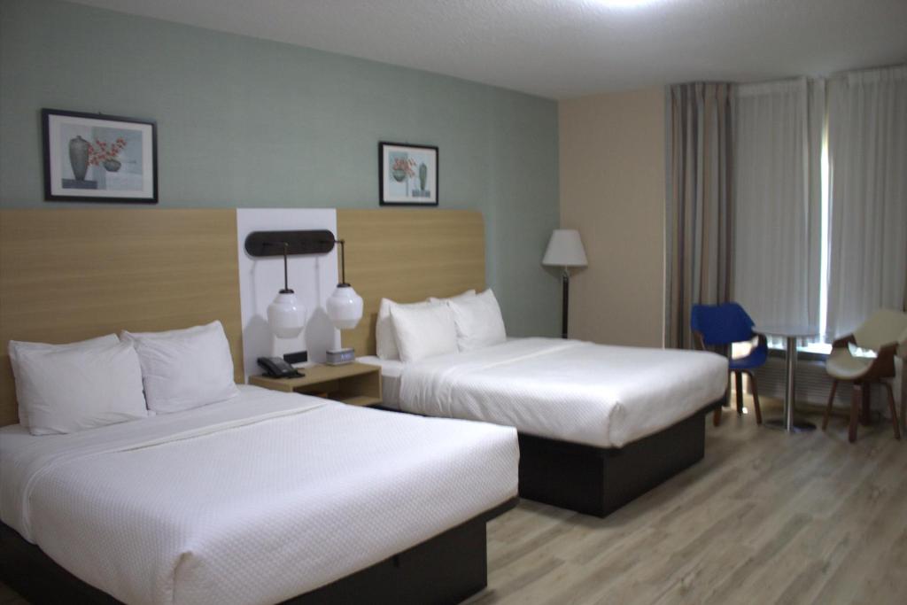 a hotel room with two beds and a table at Quality Inn Southampton in Southampton
