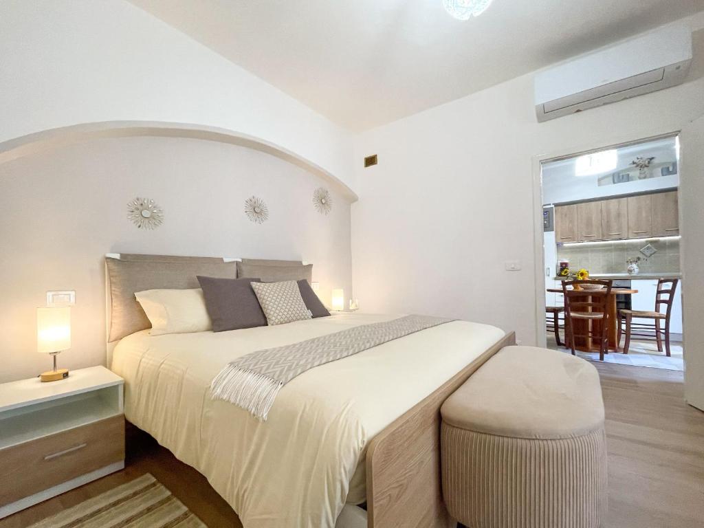 a white bedroom with a large bed and a table at Pietro Guest House in Cortona