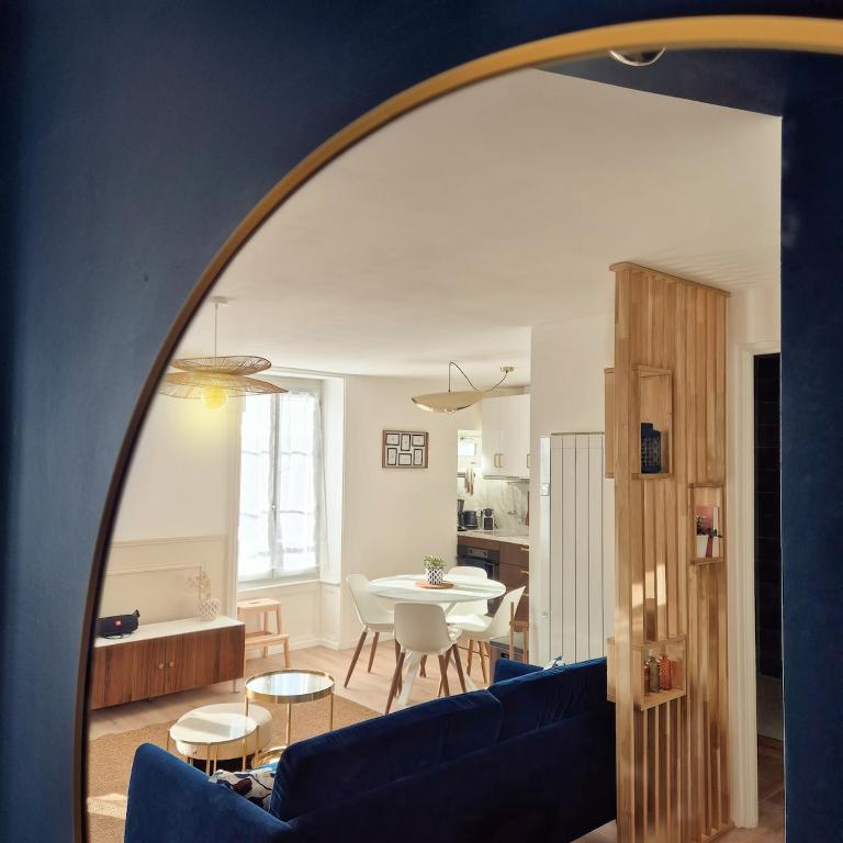 a living room with a blue couch and a table at Le Saphir in Poligny