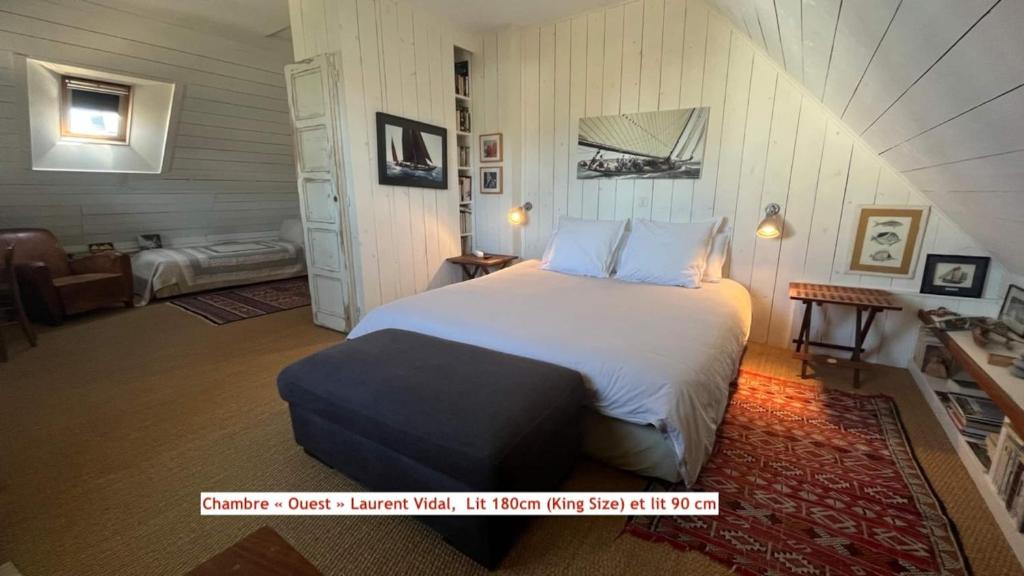 a bedroom with a large bed in a attic at Chambre d'hôtes Ouest Laurent Vidal in Plouharnel