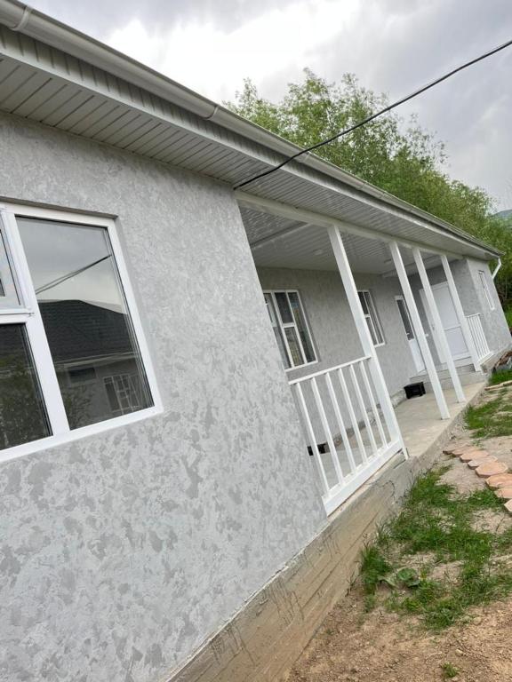 a house with white windows on the side of it at Kabyl Guest House in Tossor