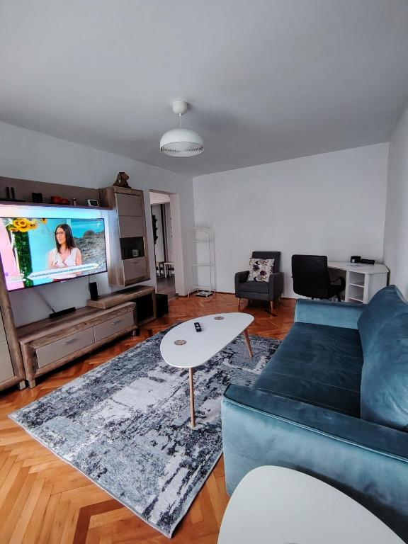 a living room with a blue couch and a flat screen tv at Adrian Home, Central in Ploieşti