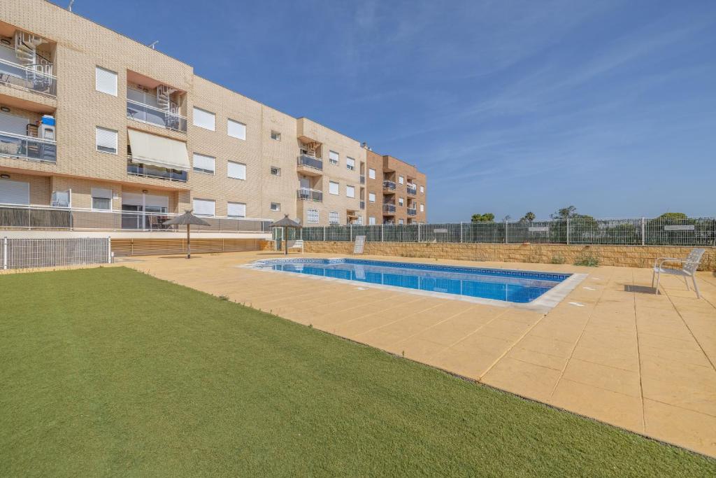 a swimming pool in front of a apartment building at Planta baja Marita in Deltebre