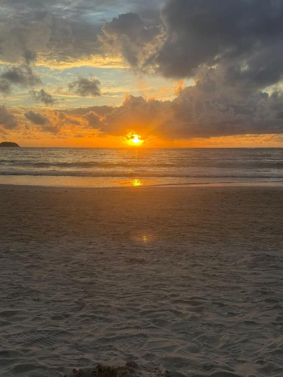 a sunset on a beach with the ocean at Vibes Solution in Patong Beach