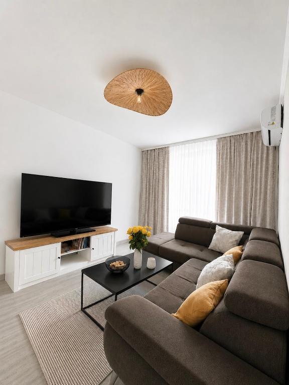 a living room with a couch and a flat screen tv at APARTAMENT 3 camere Neptun in Neptun