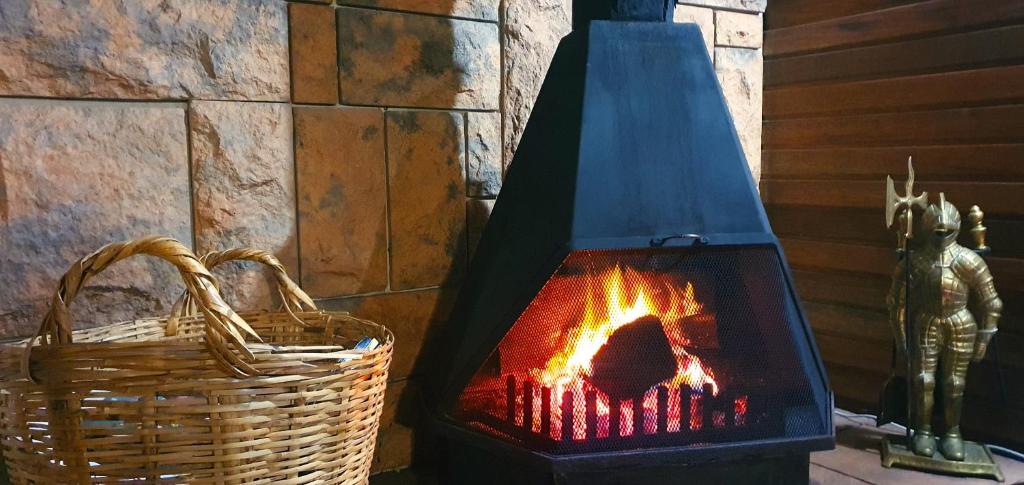 a fireplace in a room with a basket next to it at Summer Villa in Mossel Bay