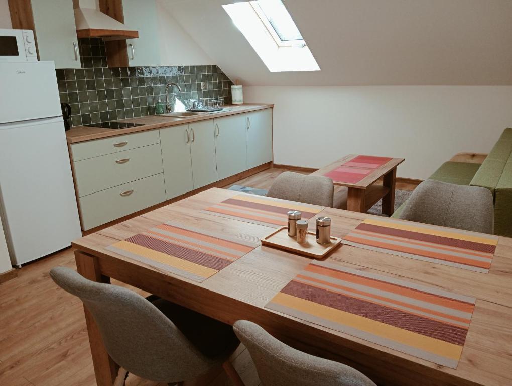 a kitchen with a wooden table with chairs and a kitchen at Apartament Miłków Karkonosze in Miłków
