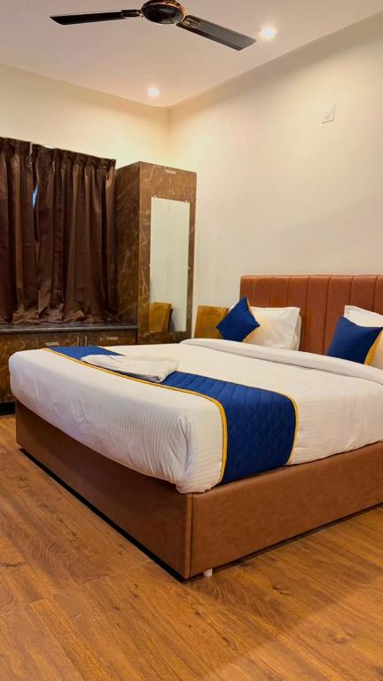 a bedroom with a large bed with blue pillows at Hotel Vakula Matha Grand in Tirupati