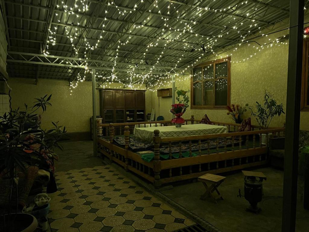 a room with a large bed with lights on the ceiling at Olzho Guest House in Karakol