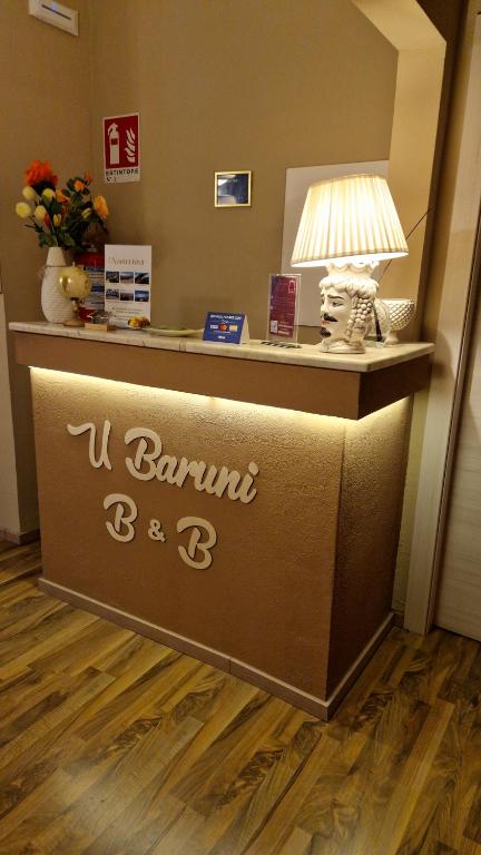 a hotel reception desk with a sign that says u boutique bar at U Baruni B&B in Messina
