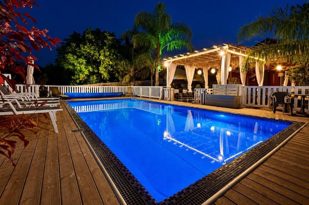 a swimming pool with blue water at night at וילה מקסים בחוסן - וילה מהממת עם בריכה, ג'קוזי וסאונה in H̱osen