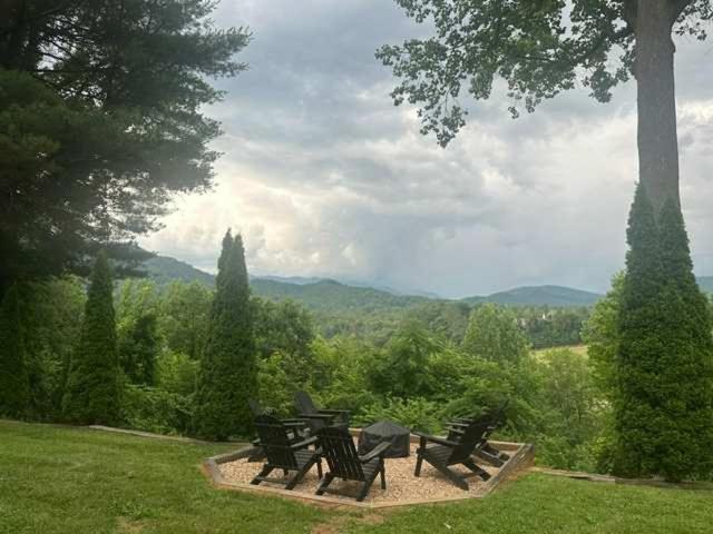 a group of picnic tables and chairs in a field at Riverhill Ridge in Sylva