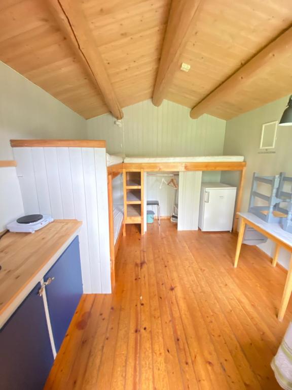 a large room with wooden floors and a wooden ceiling at Fossen Camping Fagernes in Døvre