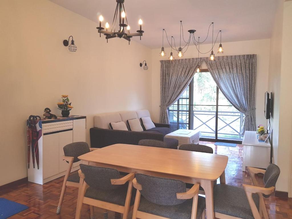 a living room with a table and a couch at Cozy Modern Quiet Garden in Tanah Rata