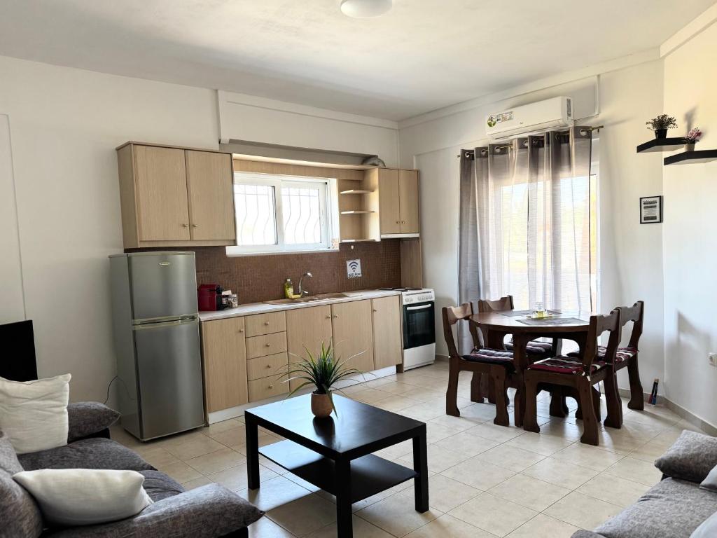 a kitchen and living room with a table and chairs at Serenity home in Souda