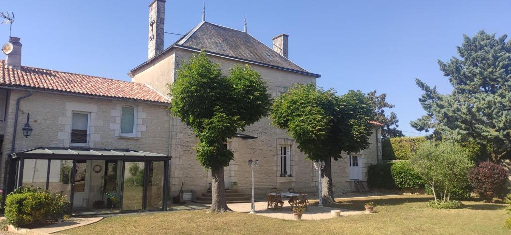 an old house with trees in front of it at Le Gîte et le Couvert in Bellefoye